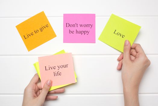 The hand lays out motivational cards. Color sheets with quotes. Visualization Board, self-discipline, development, training. Flat lay, top view. plan, strategy, concept, future.