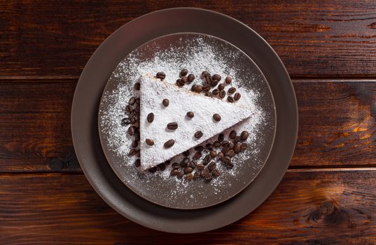 A piece of chocolate cake with sugar and coffee beans. Food, dessert, sweet. Biscuit, brownie, tiramisu, cheesecake. Cook at home. Bakery products.