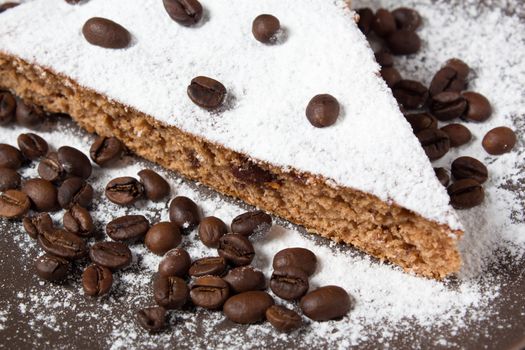 A piece of chocolate cake with sugar and coffee beans. Food, dessert, sweet. Biscuit, brownie, tiramisu, cheesecake. Cook at home. Bakery products.