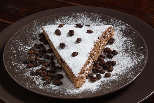 A piece of chocolate cake with sugar and coffee beans. Food, dessert, sweet. Biscuit, brownie, tiramisu, cheesecake. Cook at home. Bakery products.