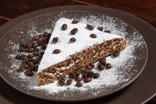 A piece of chocolate cake with sugar and coffee beans. Food, dessert, sweet. Biscuit, brownie, tiramisu, cheesecake. Cook at home. Bakery products.