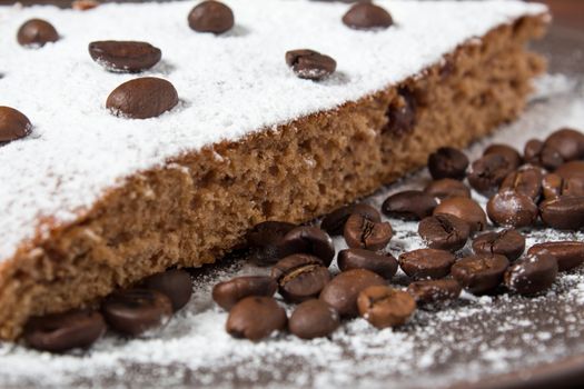 A piece of chocolate cake with sugar and coffee beans. Food, dessert, sweet. Biscuit, brownie, tiramisu, cheesecake. Cook at home. Bakery products.