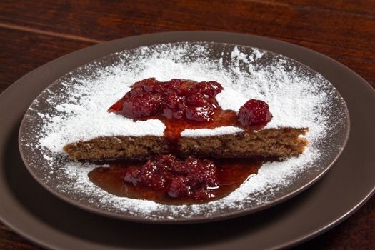 A piece of cake with strawberry jam and sugar. Dessert, food, sweet, baking. Biscuit, brownie, tiramisu, cheesecake. Cook at home, homemade, closeup, Bakery products.
