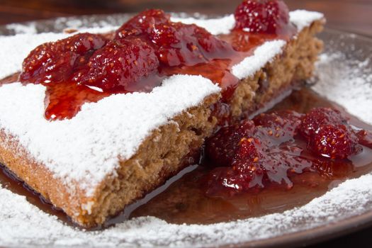 A piece of cake with strawberry jam and sugar. Dessert, food, sweet, baking. Biscuit, brownie, tiramisu, cheesecake. Cook at home, homemade, closeup, Bakery products.