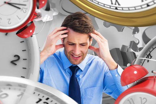 Businessman sitting on the floor with headache against grey vignette