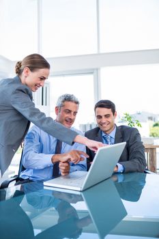 Business people looking at laptop computer in office