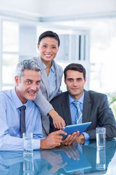 Business people looking at tablet computer in office