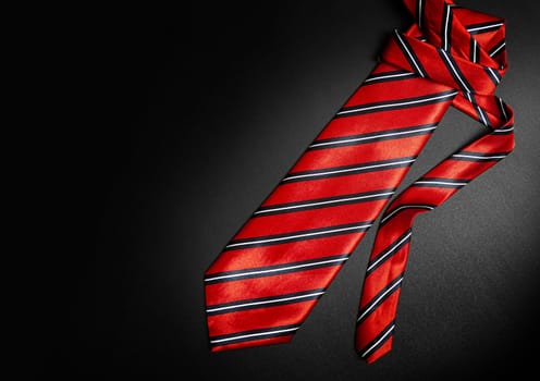 Red men's striped tie isolated on black background. With clipping path.