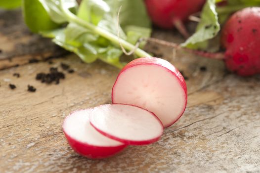 Close-up of sliced fresh harvested radish, nutritious organic ingredient, on a wooden rustic table