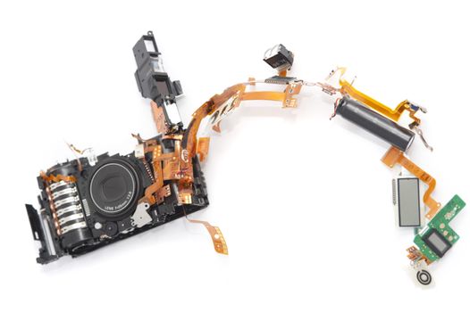 Dismantled camera lying in parts on white with the components spread out in an arc forming a border with copy space
