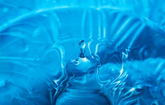 Water splash close-up. Drop of water. Blue water drop. Falling blue water surface with splash and air bubbles