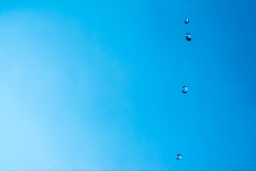 Water splash close-up. Drop of water. Blue water drop. Falling blue water surface with splash and air bubbles