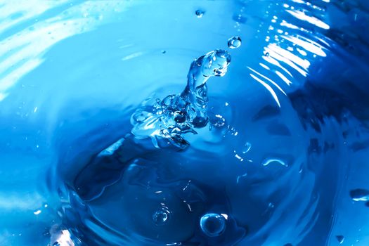 Water splash close-up. Drop of water. Blue water drop. Falling blue water surface with splash and air bubbles