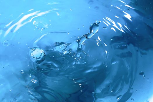 Water splash close-up. Drop of water. Blue water drop. Falling blue water surface with splash and air bubbles