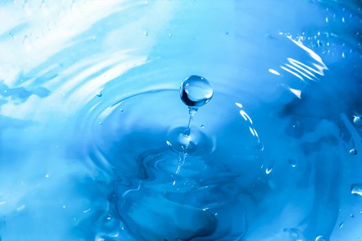 Water splash close-up. Drop of water. Blue water drop. Falling blue water surface with splash and air bubbles