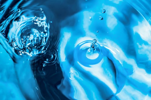 Water splash close-up. Drop of water. Blue water drop. Falling blue water surface with splash and air bubbles