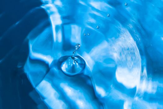 Water splash close-up. Drop of water. Blue water drop. Falling blue water surface with splash and air bubbles