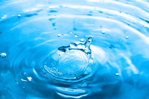 Water splash close-up. Drop of water. Blue water drop. Falling blue water surface with splash and air bubbles