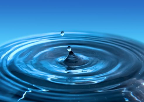 Water splash close-up. Drop of water. Blue water drop. Falling blue water surface with splash and air bubbles