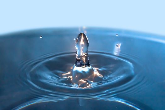 Water splash close-up. Drop of water. Blue water drop. Falling blue water surface with splash and air bubbles