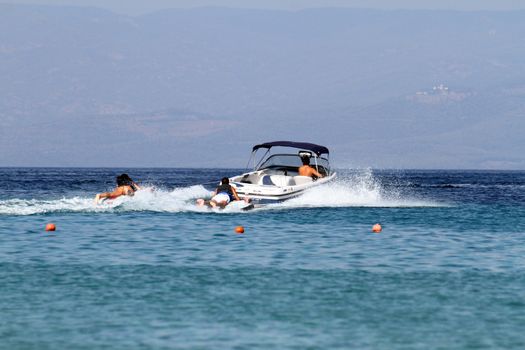 a speedboat pulls people skating in the water