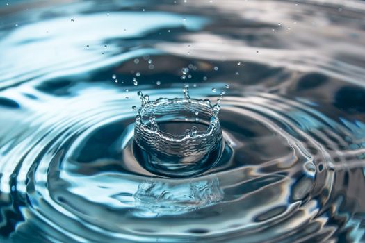 Water splash close-up. Drop of water. Blue water drop. Falling blue water surface with splash and air bubbles