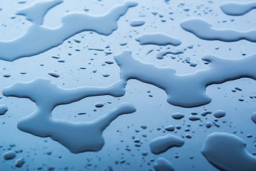 Water on a blue background. Blue drops of water on the glass. Water stains.