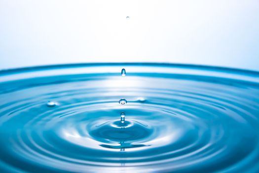 Water splash close-up. Drop of water. Blue water drop. Falling blue water surface with splash and air bubbles