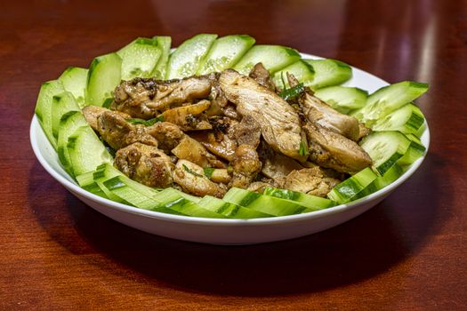 Vietnamese lemongrass grill chicken served with sliced cucumber on a big plate