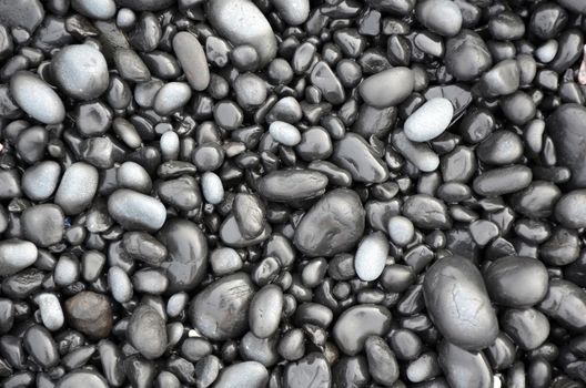 Shiny black lava pebbles on oregon beach