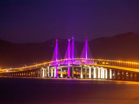 Penang Second Bridge with purple lighting in dawn hour.