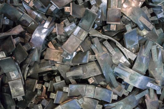 Many complex aluminium castings with burrs flat background with selective focus. View from above