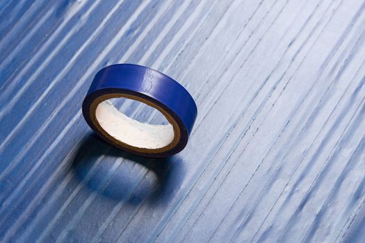 one roll of old blue pvc duct tape on surface covered by same tape