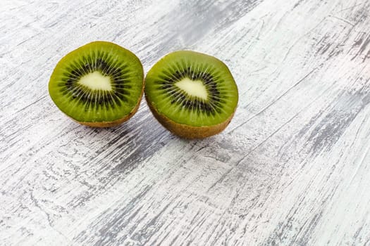 Two green kiwi halfs on  rustic looking background