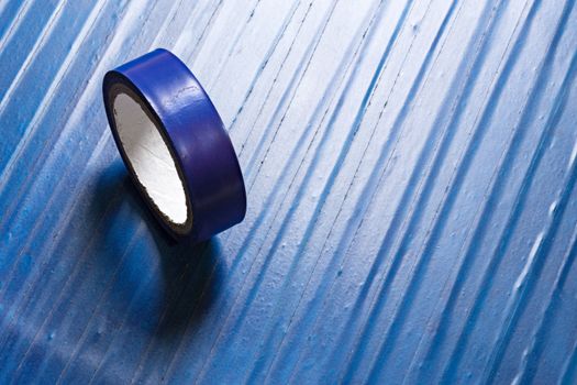 one roll of old blue pvc duct tape on surface covered by same tape