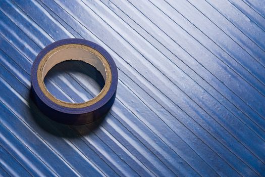 one roll of old blue pvc duct tape on surface covered by same tape