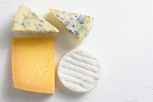 Cheese platter: yellow Maasdam, white Camembert and blue cheese Dor Blue on white background. Copy space. Concept serving cheese. Top view.