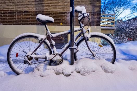 Bike covered in snow during snow storm