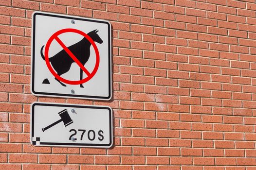 No dog pooping sign on brick wall