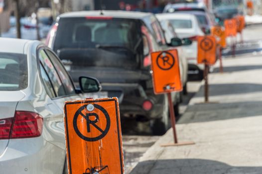 No parking signs next to parked cars in Montreal