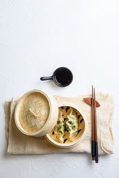Chinese snacks. chinese steamed dumpling. Chinese Traditional cuisine in wooden steamer, dumplings snack , on linen cloth served on white textured stone table top view
