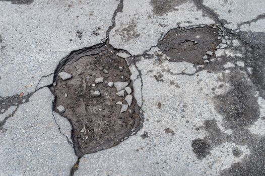 Large rounded pothole filled with water in Montreal