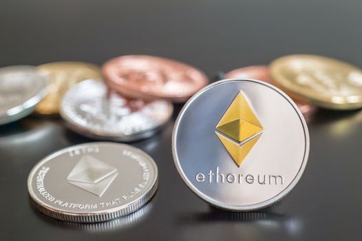 Cryptocurrency Ethereum metallic coins over grey background