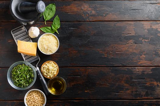 Fresh ingredients for pesto genovese Italian food cooking ingredients on dark background with rustic wooden chopping board, top view, copy space on side.