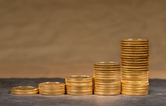 Concept illustration of growth of price of gold with stacks of gold eagle US Treasury golden coins