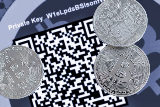 Cryptocurrency Bitcoin metallic coins, QR code and paper wallet.