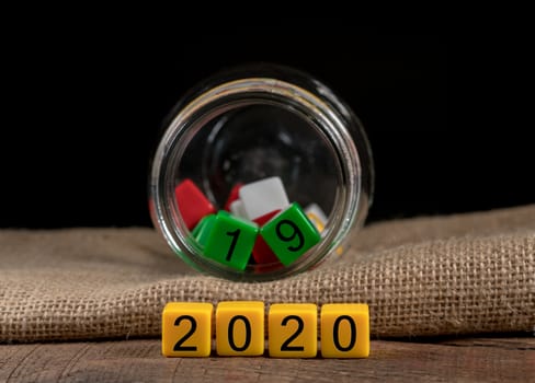 2019 being put back in the jar as dice for 2020 is spread on wooden table for New Years celebrations