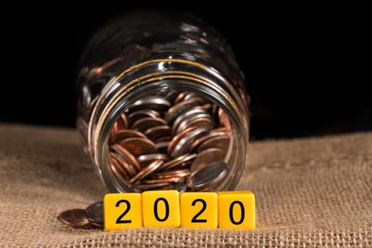 Cash in savings jar for good luck as dice for 2020 is spread on table for New Years celebrations
