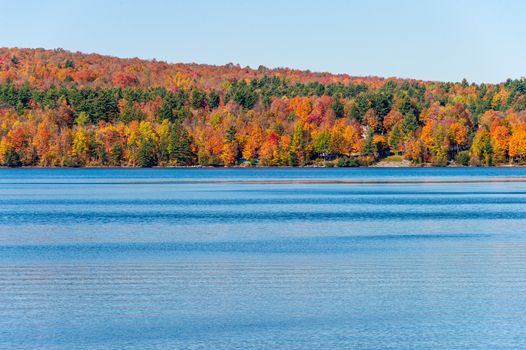 Ayer's Cliff Lake & trees with autumn foliage  in the Quebec countryside