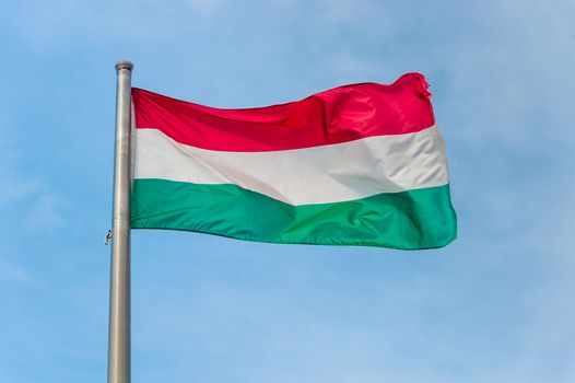 Hungarian national flag over blue sky